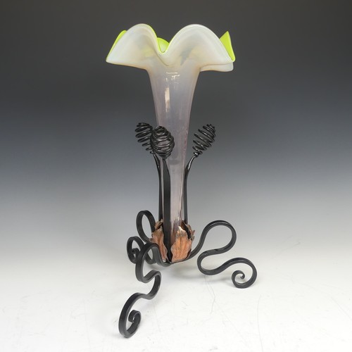 71 - A 20thC glass and wrought iron Epergne, with tripod iron base and copper leaves enclosing trumpet sh... 