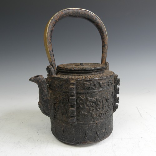 86 - A Japanese cast iron Tetsubin, of cylindrical form with relief work patterns, with swing handle with... 