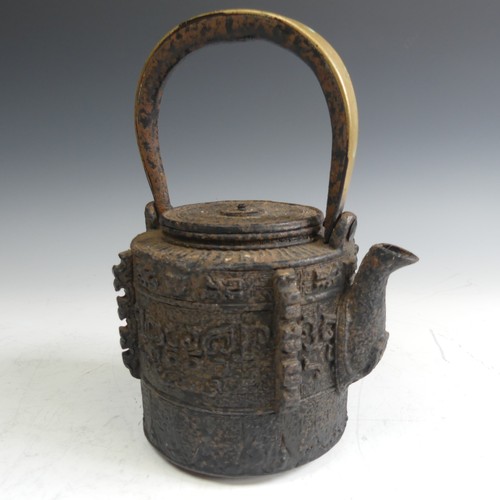 86 - A Japanese cast iron Tetsubin, of cylindrical form with relief work patterns, with swing handle with... 