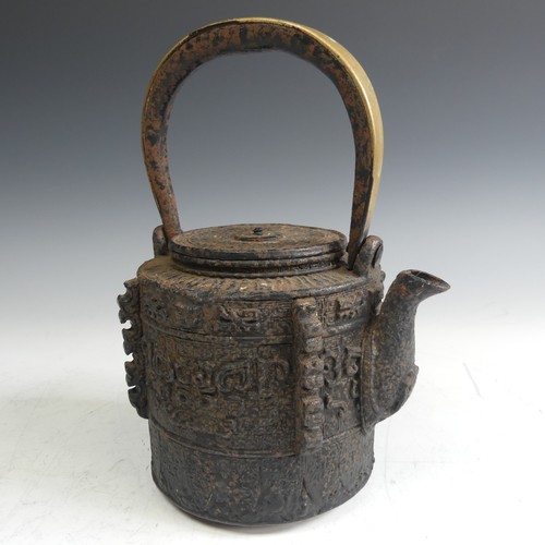 86 - A Japanese cast iron Tetsubin, of cylindrical form with relief work patterns, with swing handle with... 