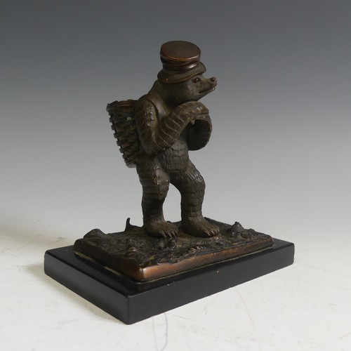 124 - A novelty Vesta holder in the form of a gilt bronze Bear, with a top hat and a basket on his back, r... 