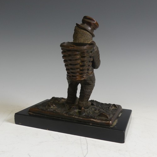 124 - A novelty Vesta holder in the form of a gilt bronze Bear, with a top hat and a basket on his back, r... 