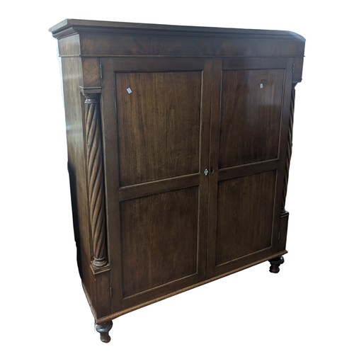 385 - A Victorian mahogany Linen Press, moulded top above two panel doors flanked by barley twist columns,... 