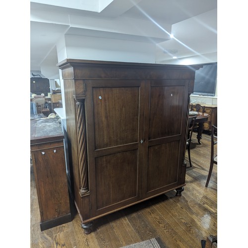 385 - A Victorian mahogany Linen Press, moulded top above two panel doors flanked by barley twist columns,... 