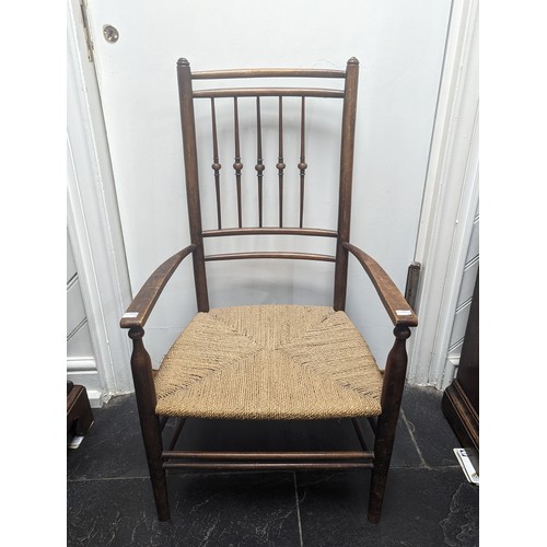 492 - An early 20th century Arts and Crafts oak rush seat side Chair, in the manner of Liberty, spindle ba... 