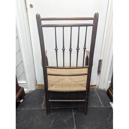 492 - An early 20th century Arts and Crafts oak rush seat side Chair, in the manner of Liberty, spindle ba... 