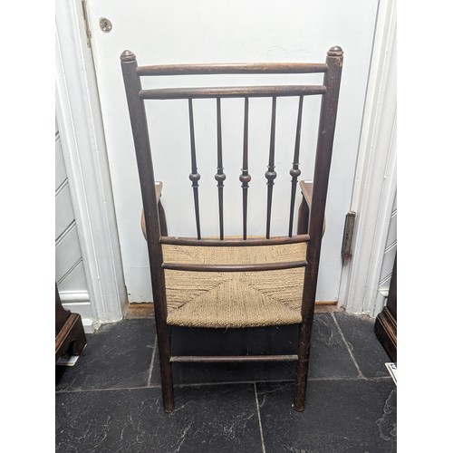 492 - An early 20th century Arts and Crafts oak rush seat side Chair, in the manner of Liberty, spindle ba... 