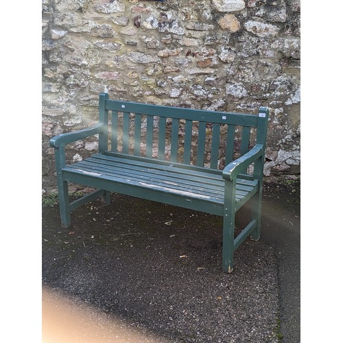 527 - A weathered green painted wooden garden Bench, W 122 cm x H 84 cm x D 57 cm.