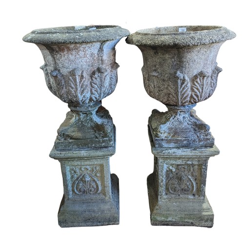 530 - A Pair of weathered reconstituted stone garden Urns of campana form, raised on Art Nouveau inspired ... 