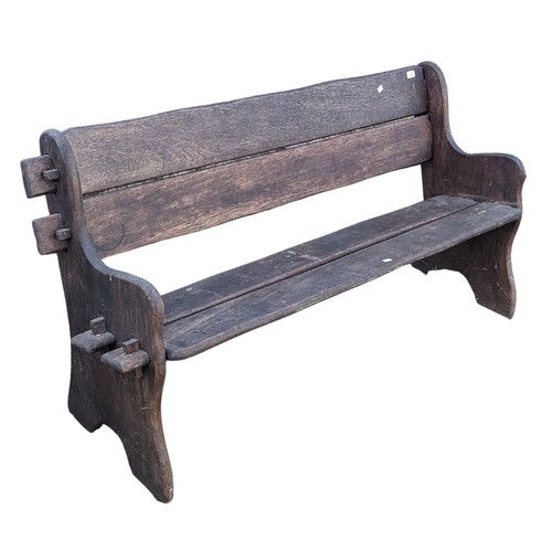 525 - A weathered West African iroko wood two seat garden Bench, with shaped ends and pegged frame, applie... 