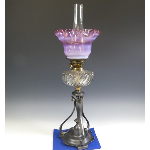 506 - A late 19thC Oil Lamp, with cranberry glass shade, raised on art nouveau style metal base, Rd No. 42... 