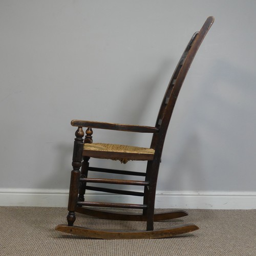 389 - An Antique elm Rocking Chair, with rush seat, W 50.5 cm x H 102 cm x D 67 cm.