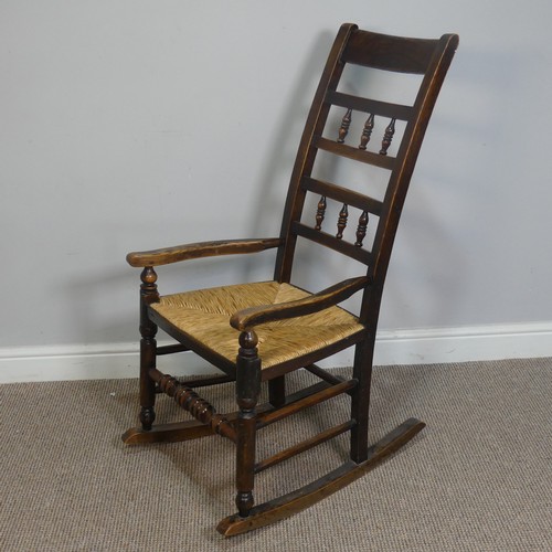 389 - An Antique elm Rocking Chair, with rush seat, W 50.5 cm x H 102 cm x D 67 cm.