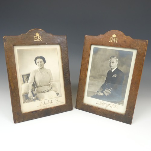A pair of portrait photographs of King George VI and Queen Elizabeth, taken by Dorothy Wilding, each signed below in black ink 'George R.I.' and 'Elizabeth R', in original leather frames with gilt Royal monograms above, photograph sizes 15 x 11.5cm approx., with easel reverses, total height 25.5cm (2)