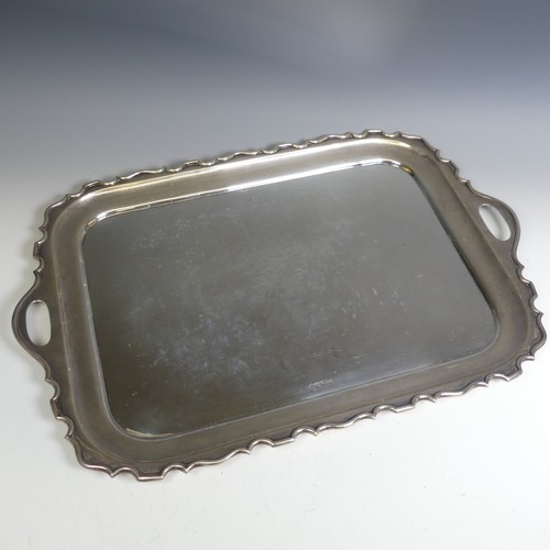 120 - A George V rectangular silver two handled Tray, with plain centre, the shaped rim with cut out oval ... 