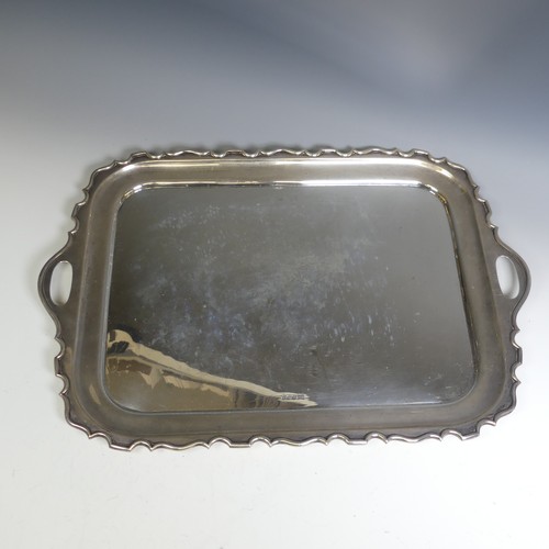 120 - A George V rectangular silver two handled Tray, with plain centre, the shaped rim with cut out oval ... 