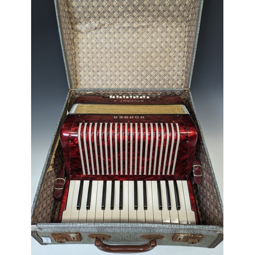 605 - A vintage Hohner Student II Accordion, with red marbled-effect body, in carry case.