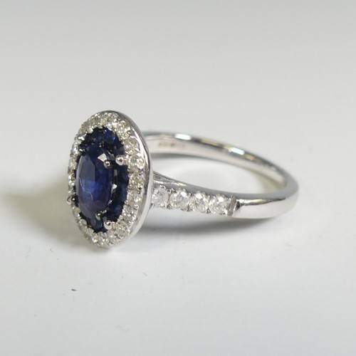 276 - A sapphire and diamond Cluster Ring, the central oval facetted sapphire, approx. 7mm long four claw ... 