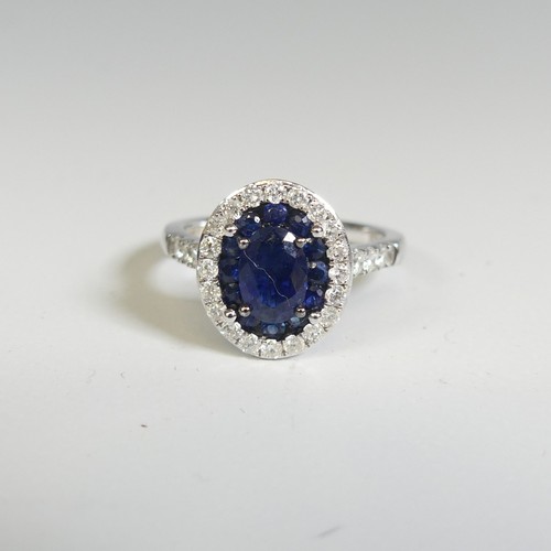 276 - A sapphire and diamond Cluster Ring, the central oval facetted sapphire, approx. 7mm long four claw ... 