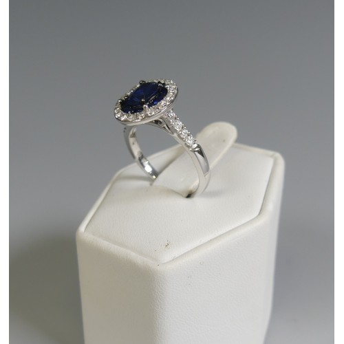 276 - A sapphire and diamond Cluster Ring, the central oval facetted sapphire, approx. 7mm long four claw ... 