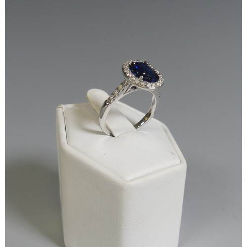 276 - A sapphire and diamond Cluster Ring, the central oval facetted sapphire, approx. 7mm long four claw ... 