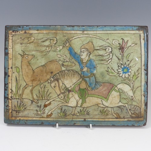 84 - A 19thC Persian pottery Tile, depicting figure on horseback, 24cm x 34.5cm.