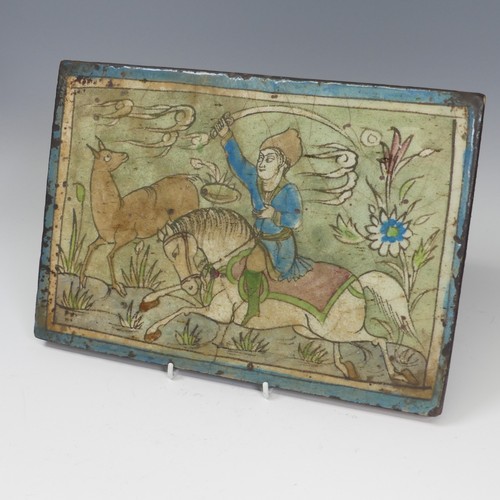 84 - A 19thC Persian pottery Tile, depicting figure on horseback, 24cm x 34.5cm.