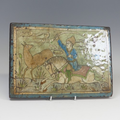 84 - A 19thC Persian pottery Tile, depicting figure on horseback, 24cm x 34.5cm.