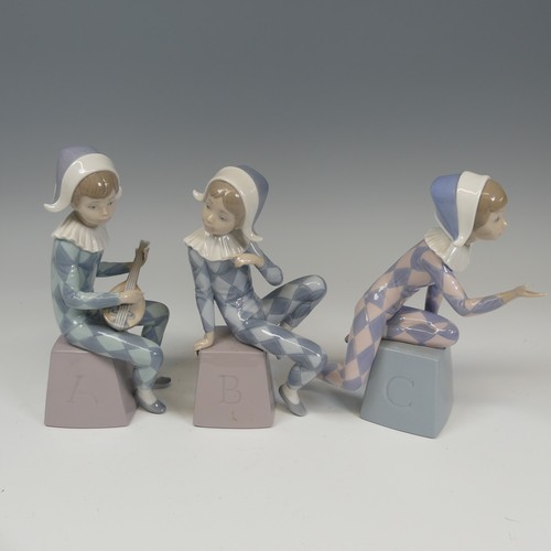 116 - A Lladro Harlequin ABC Trio, each modelled in varying positions perched on letter blocks, tallest H ... 