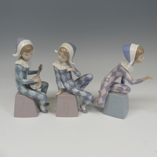 116 - A Lladro Harlequin ABC Trio, each modelled in varying positions perched on letter blocks, tallest H ... 