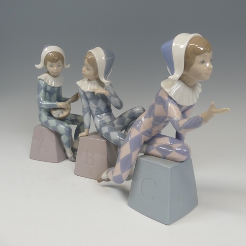 116 - A Lladro Harlequin ABC Trio, each modelled in varying positions perched on letter blocks, tallest H ... 