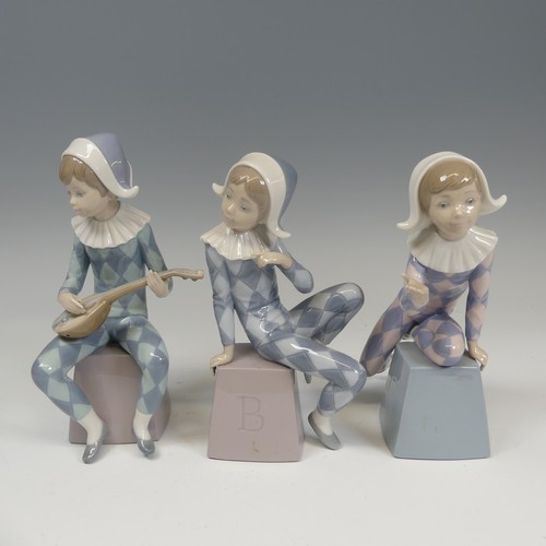 116 - A Lladro Harlequin ABC Trio, each modelled in varying positions perched on letter blocks, tallest H ... 