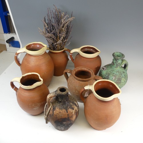 134 - A matched set of four graduated pottery Jugs, with cream glazed rims, the tallest H 29cm, together w... 