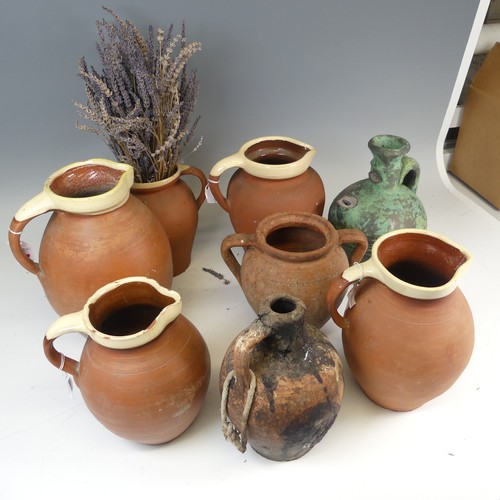 134 - A matched set of four graduated pottery Jugs, with cream glazed rims, the tallest H 29cm, together w... 