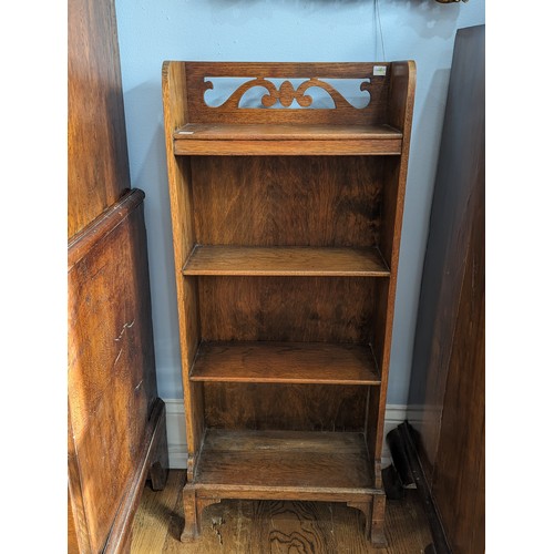 385 - An unusual Arts and Crafts oak open Bookcase, gallery pierced with stylised scrolls raised on four f... 