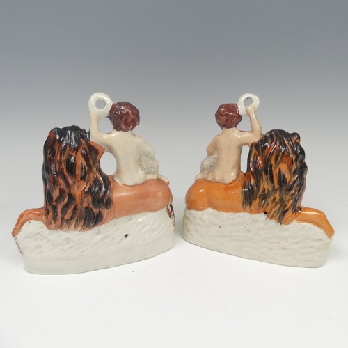 142 - A matched pair of 19thC Staffordshire pottery figural Bookends, modelled as a recumbent lion with a ... 