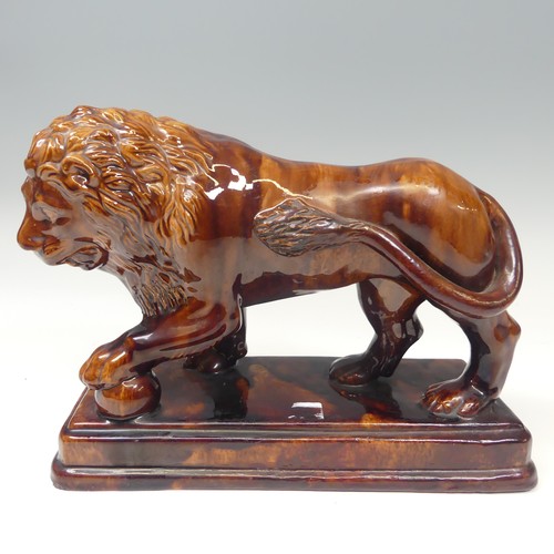 158 - A 19thC treacleware Medici lion Figure, resting its paw on a ball, raised on stepped plinth base, H ... 