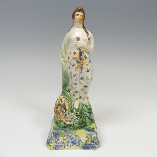 159 - An early 19thC pearlware figure of Spring, decorated in prattware palette, modelled in typical stanc... 