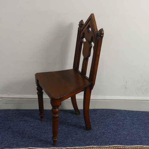 370 - A Victorian oak gothic style hall Chair, with pierced back raised on turned front legs and splayed r... 