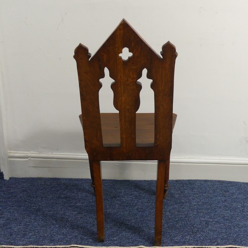 370 - A Victorian oak gothic style hall Chair, with pierced back raised on turned front legs and splayed r... 