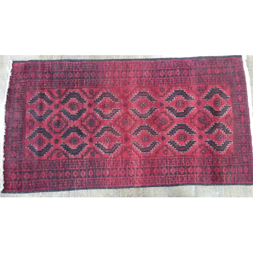 640 - Tribal Rugs; a red ground Afghan rug, wool pile on cotton base, 179cm x 94.5cm, good overall conditi... 