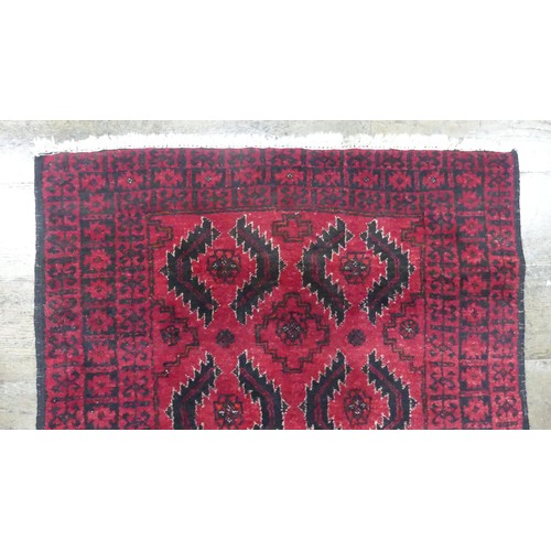 640 - Tribal Rugs; a red ground Afghan rug, wool pile on cotton base, 179cm x 94.5cm, good overall conditi... 