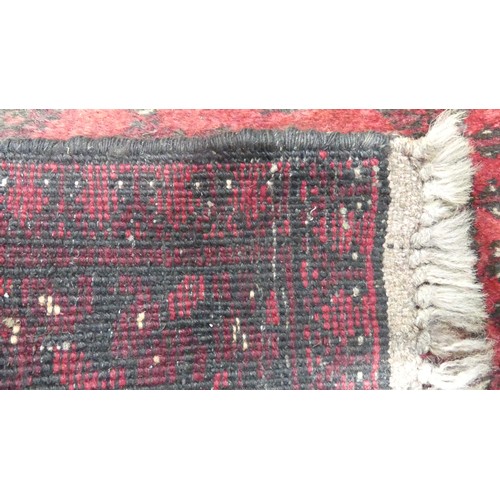 651 - Tribal Rugs; a red ground Afghan runner, wool pile on wool base, 272cm x 82cm, pile worn in places.... 