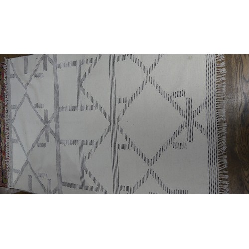 648 - A contemporary flat-weave cream ground woollen rug, 190cm x 121cm.