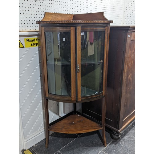 381 - An Edwardian mahogany bow-fronted corner display Cabinet, with chequer inlay raised on splayed taper... 