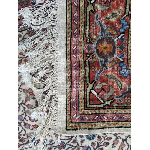 645 - Tribal rugs; a hand-knotted cream ground Persian carpet, wool pile on cotton base, with salmon-pink ... 