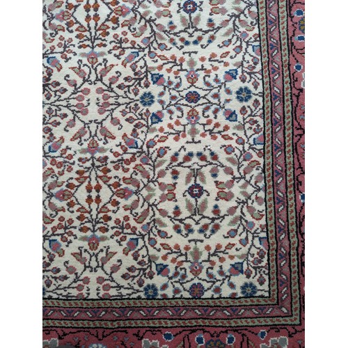 645 - Tribal rugs; a hand-knotted cream ground Persian carpet, wool pile on cotton base, with salmon-pink ... 