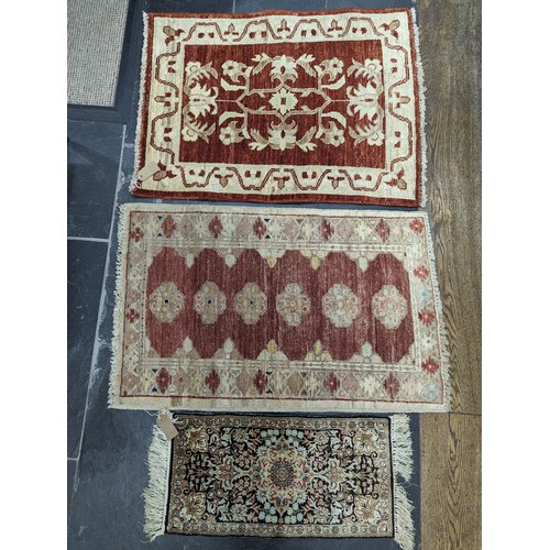 638 - Tribal Rugs; a small silk Kashmiri Mat, 72cm x 30cm, together with two other small rugs, one with ev... 