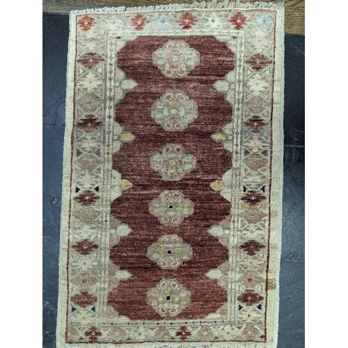 638 - Tribal Rugs; a small silk Kashmiri Mat, 72cm x 30cm, together with two other small rugs, one with ev... 