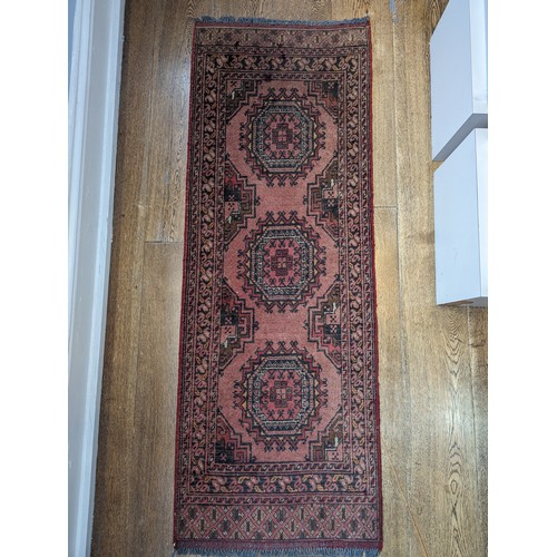 637 - Tribal Rugs; a small red ground Afghan runner, wool pile on wool base, 160cm x 67cm, together with t... 